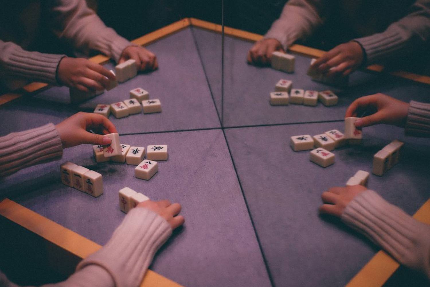 Empat pemain bermain mahjong dari sudut atas